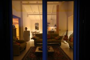 un soggiorno con un divano e una chitarra di Chalet Il Bosco dei Mille Frutti a Canossa