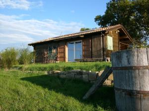 una cabaña de madera con un barril delante en Chalet Il Bosco dei Mille Frutti, en Canossa