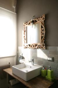 bagno con lavandino bianco e specchio di Chalet Il Bosco dei Mille Frutti a Canossa
