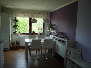 a dining room with purple walls and a table and chairs at Venkovská pohoda s výhledem na Beskydy in Vělopolí +10 photos