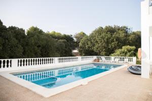 a swimming pool with a white fence around it at Apartamentos Gama in Cala Galdana