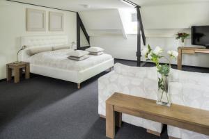una camera con letto, divano e TV di Hotel Kasteel Doenrade a Doenrade