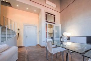 佛羅倫斯的住宿－Apartments Florence - Ricasoli Terrace，一间设有玻璃桌和白色椅子的用餐室