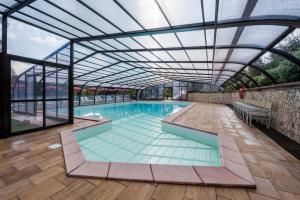 an indoor swimming pool with a glass ceiling at Il Castagno Toscana in Campiglia Marittima