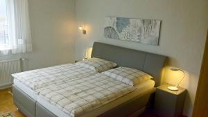 sypialnia z łóżkiem z kocem w kratę w obiekcie Premium-Ferienwohnungen Bergblick im Haus Hopfe w mieście Hahnenklee-Bockswiese