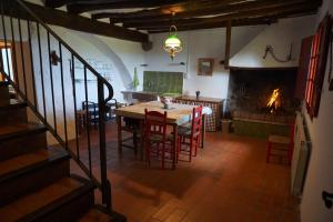 comedor con mesa, sillas y chimenea en Mas La Mata, en Olot