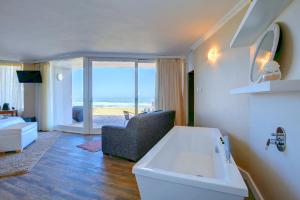 een badkamer met een wastafel en een kamer met uitzicht op de oceaan bij Dune Villa Wilderness in Wilderness