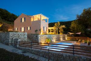 a house with a stone wall and a swimming pool at Villa Authentica Lopud, Dubrovnik in Lopud