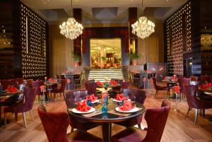 a dining room with tables and chairs and chandeliers at Pickalbatros White Beach Resort - Hurghada in Hurghada