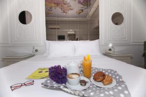 a breakfast tray with coffee and pastries on a bed at Hotel Etap Mola in Ankara
