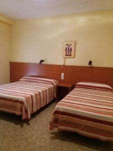 
a hotel room with two beds and two nightstands at Hotel Borja in El Puig
