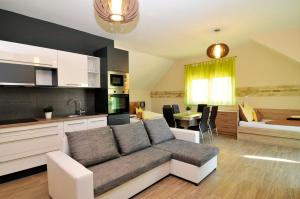 a living room with a couch and a kitchen at Hotel Corso in Siófok