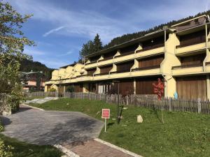 a large yellow building with a sign in front of it at Residenza Silvana in Madonna di Campiglio