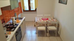 アルゲーロにあるCasa Vacanze Sardinia Sunの小さなキッチン(テーブル、椅子、コンロ付)