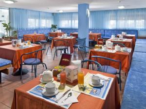 una sala da pranzo con tavoli e sedie in un ristorante di Hotel Giannino a Porto Recanati