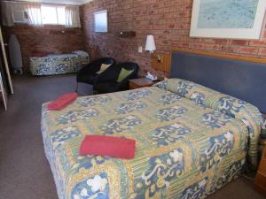 
a bedroom with a bed and a desk at Beach Drive Motel in Batemans Bay
