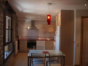 a kitchen with a table and chairs and a refrigerator at El Mirador de Ainsa in Aínsa