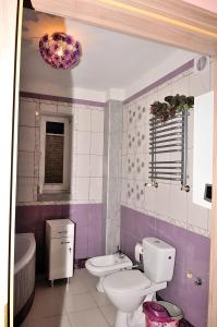 uma casa de banho com 2 WC e um lavatório em Banana Apartment em Toruń