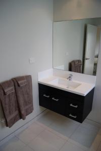 a bathroom with a sink and a mirror at Waihi Beach Getaway-Studio, Ensuite & Private Deck in Waihi Beach