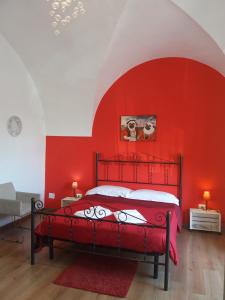 カターニアにあるB&B Favola Mediterraneaの赤い壁のベッド付きの赤いベッドルーム