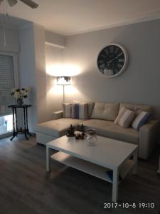 a living room with a couch and a clock on the wall at Piso Vacacional in San Juan de Alicante
