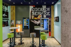 a coffee shop with stools and a vending machine at Ibis Budget Salzburg Airport - Self-Check-In in Salzburg