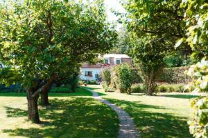 a path in a garden with trees and a house at Agda Lund Bed & Breakfast in Kivik