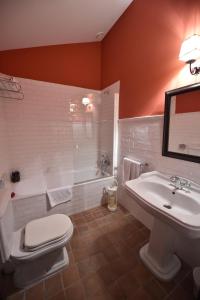 een badkamer met een toilet, een wastafel en een bad bij Batzarki in Avellaneda