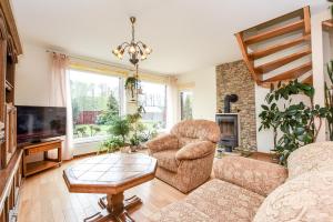 a living room with a couch and chairs and a fireplace at Apartamentai Pluke in Palanga