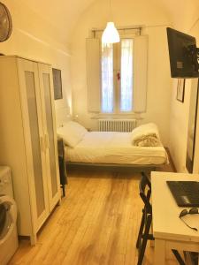 een kleine kamer met een bed en een bureau met een laptop bij Appartamento Maggiore in Bologna