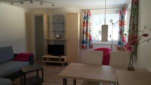 sala de estar con sofá, mesa y TV en Apartment Hörhager en Mayrhofen