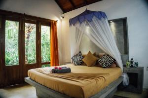 1 dormitorio con 1 cama con dosel en Surf N Sun - Arugam Bay, en Arugam Bay