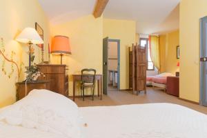 a hotel room with a bed and a desk and a bedroom at Domaine Grand Guilhem in Cascastel-des-Corbières