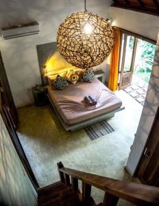 a small bedroom with a bed with a chandelier at SURF N SUN - Arugam Bay in Arugam Bay