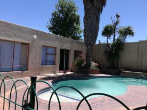 a small swimming pool in front of a house at Naisar's Apartments Primrose,Johannesburg in Johannesburg