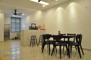 a dining room with a black table and chairs at Imperial Cottage in Melaka
