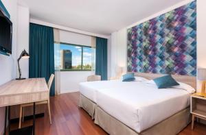 um quarto com uma cama, uma secretária e uma janela em Hotel Guadalajara & Conference Center Affiliated by Meliá em Guadalajara