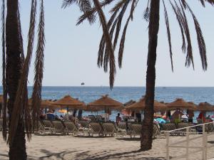 a beach with chairs and umbrellas and the ocean at Terrace Costa Hotel in Fuengirola