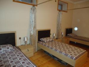 two beds in a room with wooden floors at Guesthouse Khazar in old city in Baku
