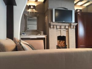 a living room with a fireplace with a tv above it at The Tudor Hotel in Harrow