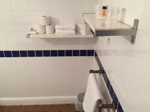 a bathroom with blue and white tiles and towels at The Tudor Hotel in Harrow