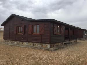 a large wooden house with windows on a field at Casa Rural Cuesta Grande in Pelabravo