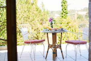 een tafel en twee stoelen op een veranda met eten erop bij Vamos Palace Apartments in Vamos