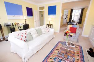 un soggiorno con divano bianco e tavolo di JOIVY Luxurious 2BR flat in Pimlico, near Warwick sq a Londra