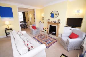 un soggiorno con 2 divani bianchi e una TV di JOIVY Luxurious 2BR flat in Pimlico, near Warwick sq a Londra