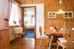 a kitchen with wooden walls and a table and chairs at Hotel Kreuzberg Monte Croce in Sesto