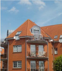 ビューズムにあるResidenz Rosengrund mit Schwimmbad und Saunaの赤レンガ造りのオレンジ色の瓦屋根