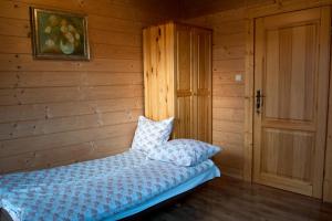1 dormitorio con 1 cama en una habitación de madera en Pokoje gościnne "Mraźnica" en Zakopane