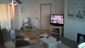 a living room with a tv and a zebra on the screen at Apartment Raversijde with Seaview in Ostend