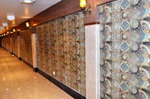 a hallway with a wall covered in ceramic tiles at Hotel Continental Blue in Bikaner